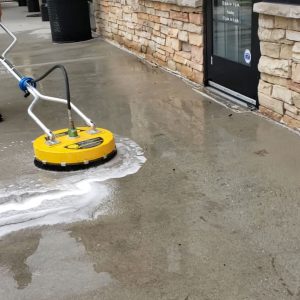 pressure washing the sidewalk in front of a business